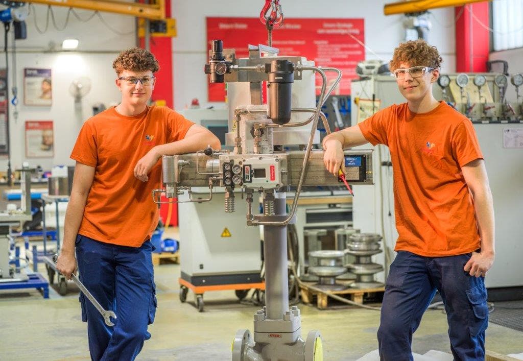 Zwei Lehrlinge an einer Ständerbohrmaschine