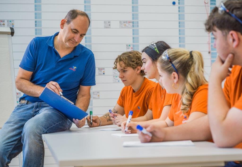 Ausbilder erklärt Lehrlingen etwas im Schulungsraum